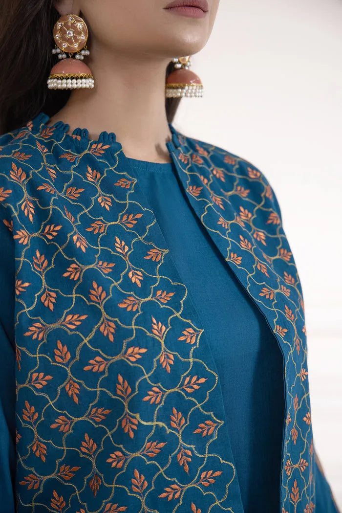 Teal embroidered jacket with orange patterns worn by a person, on a plain background