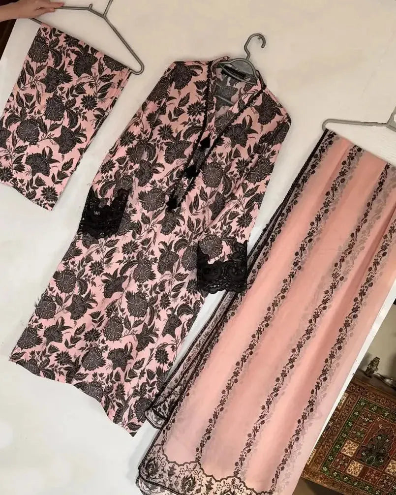 Pink and black floral patterned fabric on hangers against a white background
