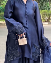 Navy blue traditional outfit with intricate designs on a street background