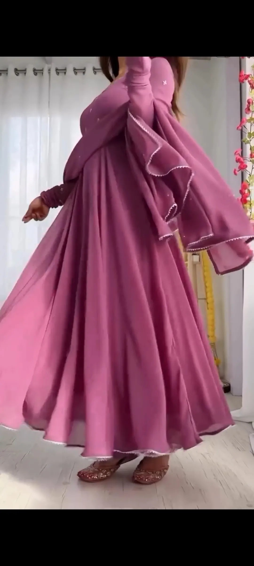 Person wearing a long, flowing pink dress indoors.