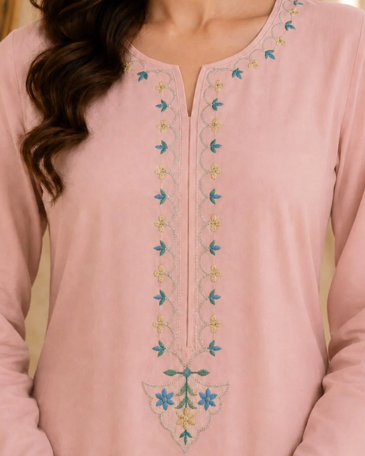 Pink embroidered top worn by a person with a blurred background
