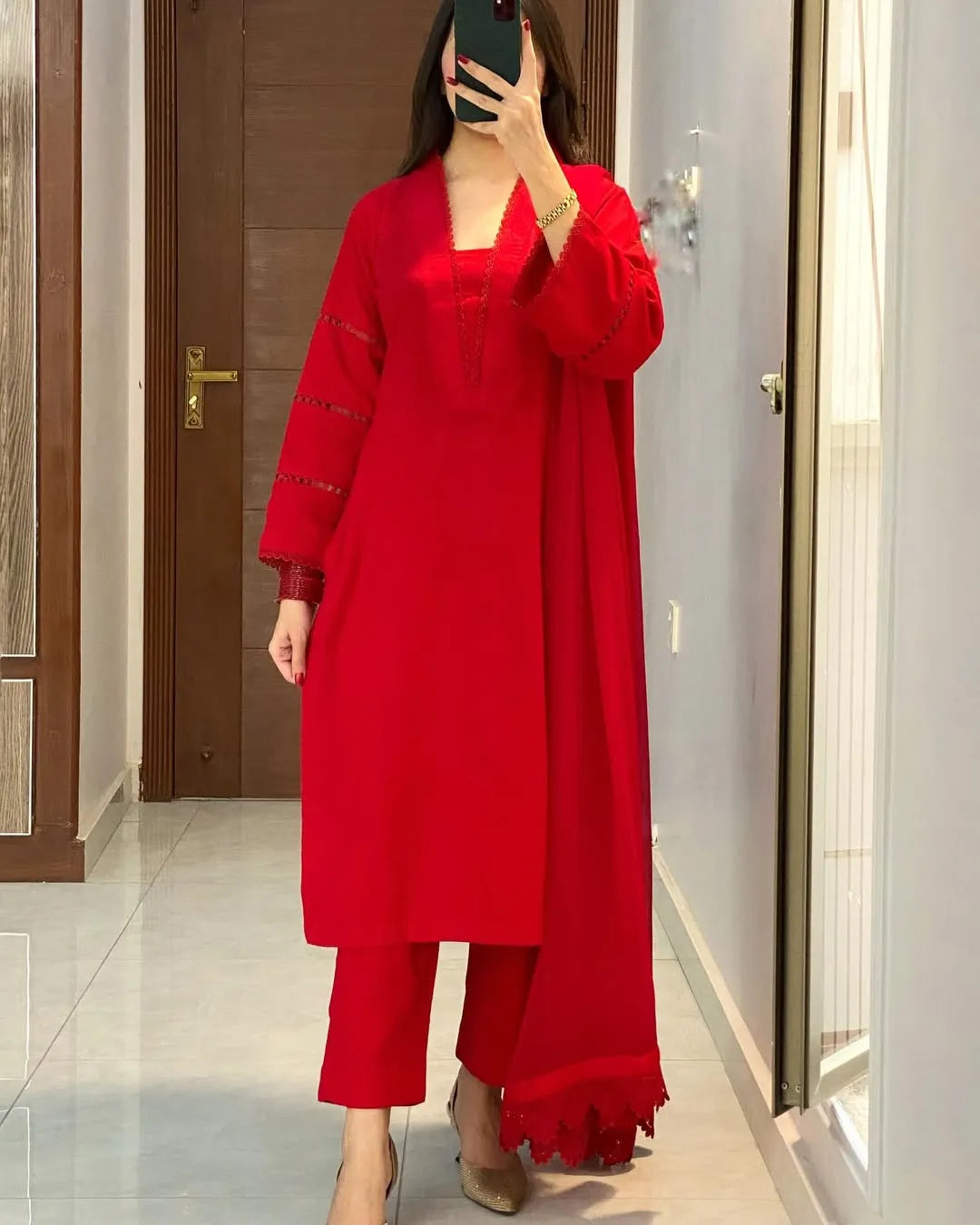 Person wearing a red outfit with long sleeves and pants in a room.