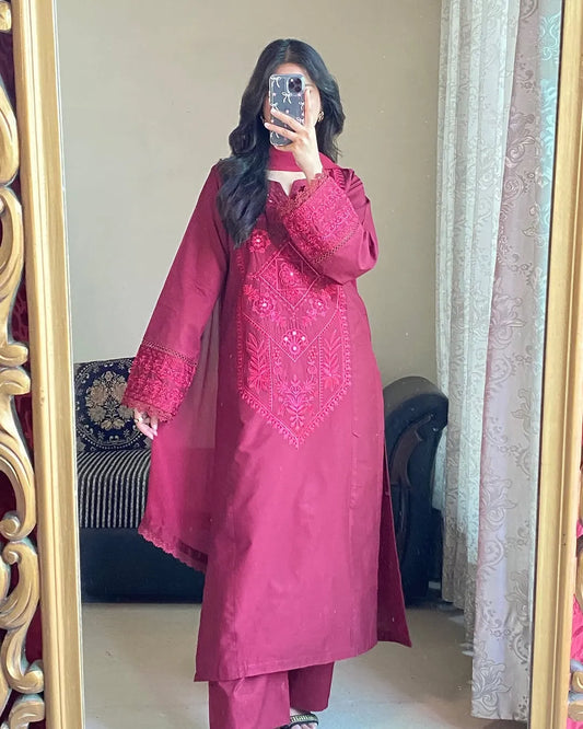 Person wearing a pink embroidered traditional outfit in front of a mirror.