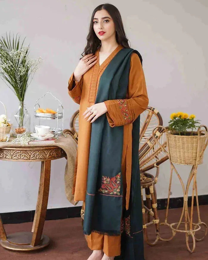 Woman wearing a traditional outfit with a green and brown design in a decorative setting.