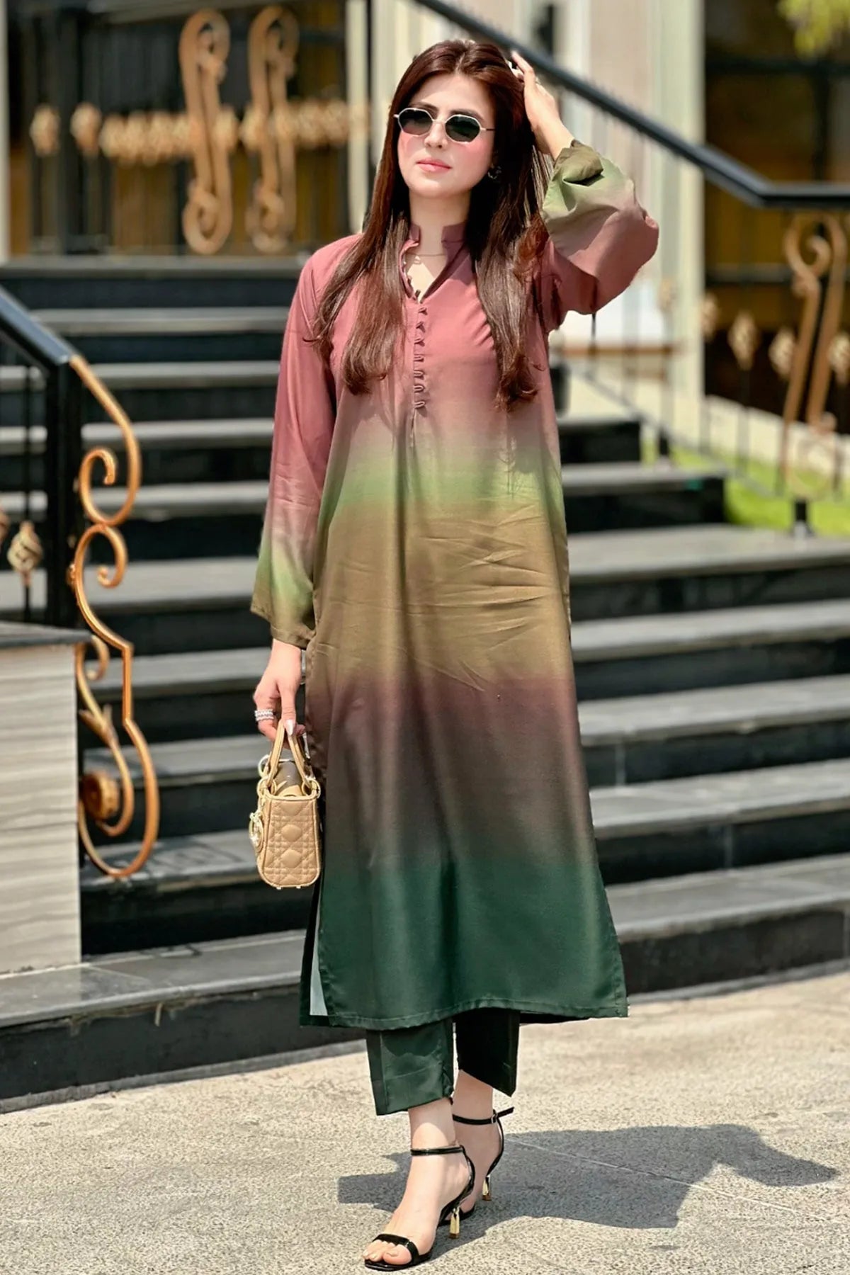 Woman wearing a gradient dress standing on steps outdoors