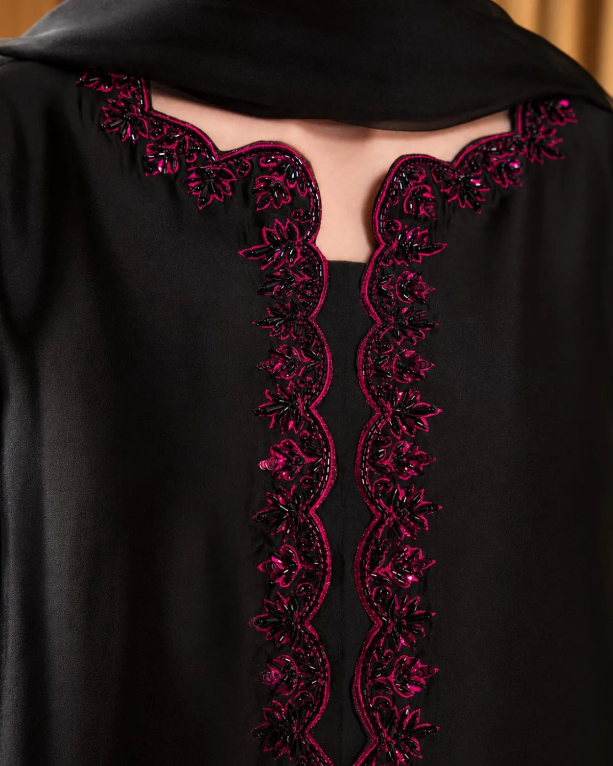 Black garment with intricate pink embroidery