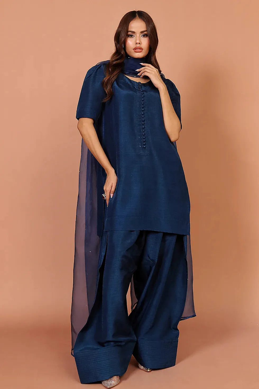 Woman wearing a blue outfit with a plain background