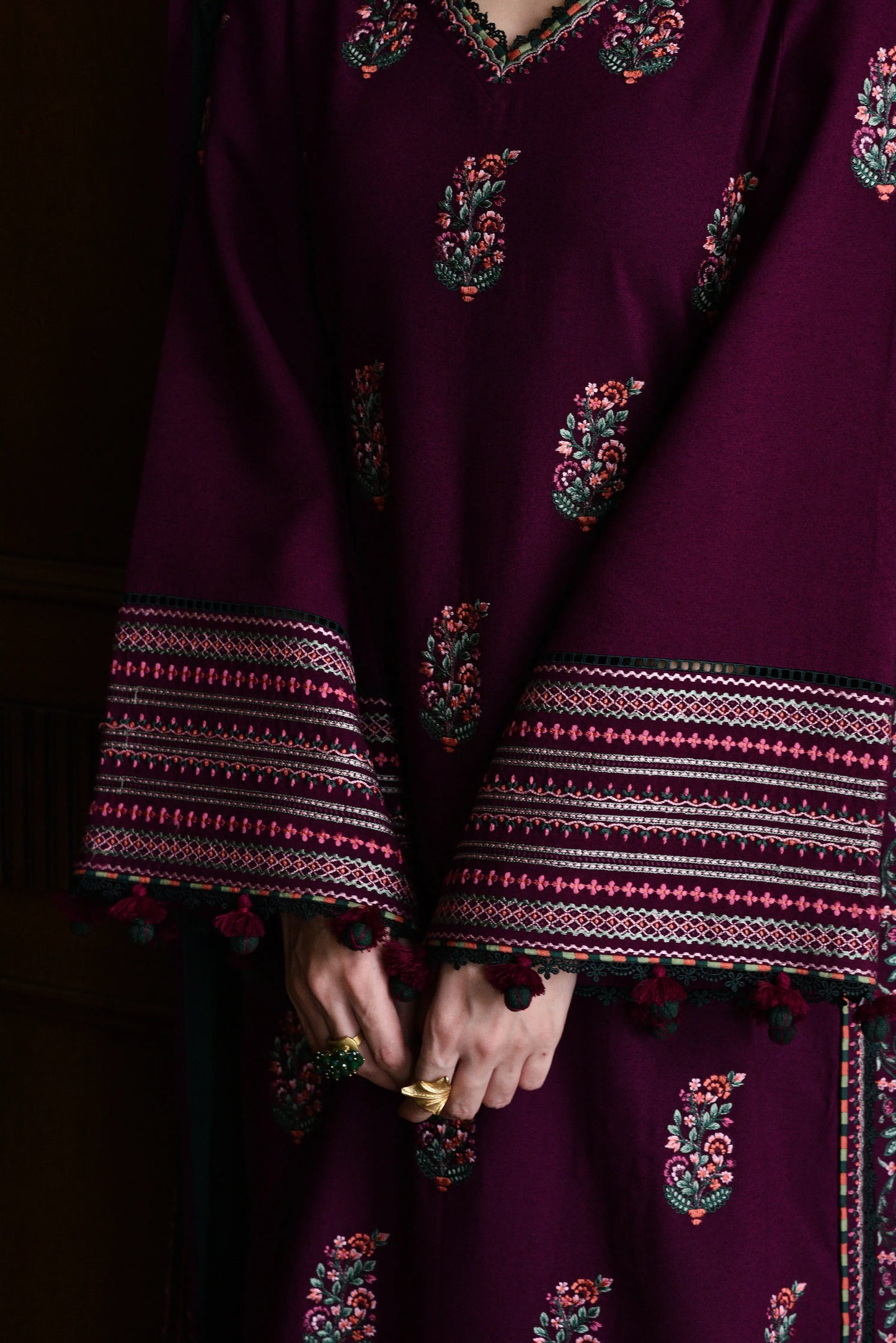 Close-up of a dark purple traditional outfit with intricate patterns and embroidery.