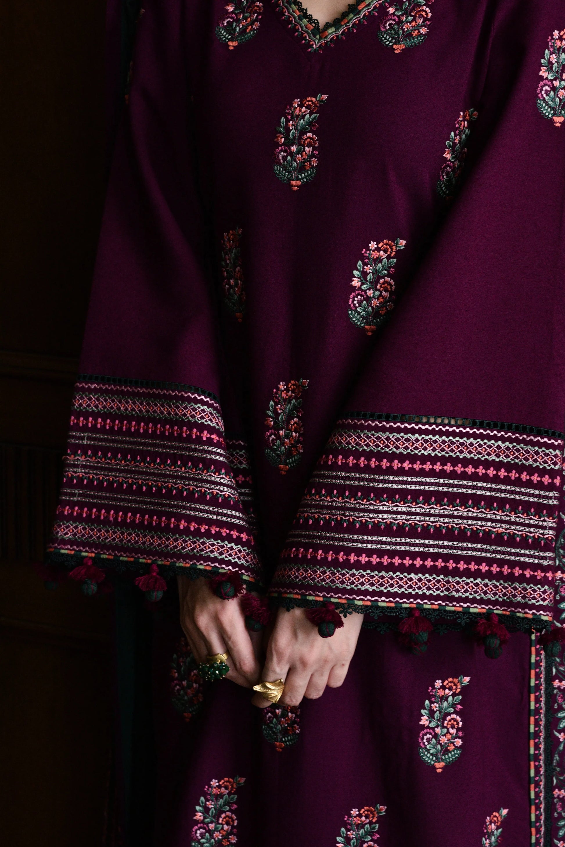 Close-up of a dark purple traditional outfit with intricate patterns and embroidery.