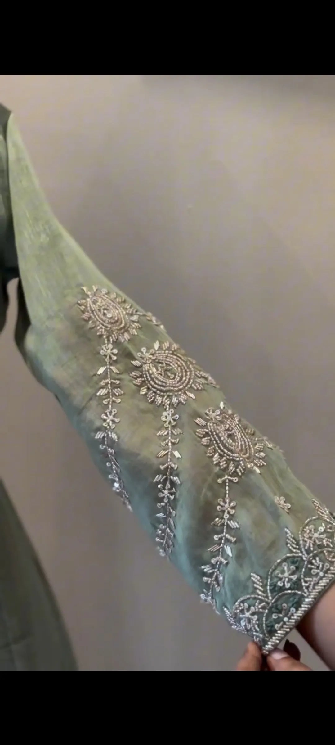 Decorative fabric with intricate silver embroidery on a plain background