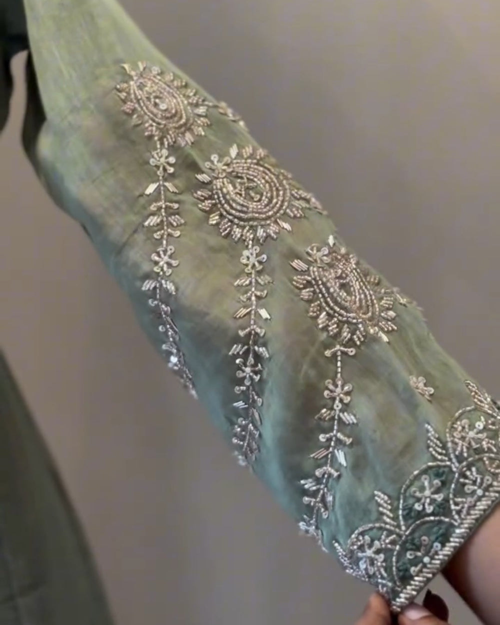 Decorative fabric with intricate silver embroidery on a plain background