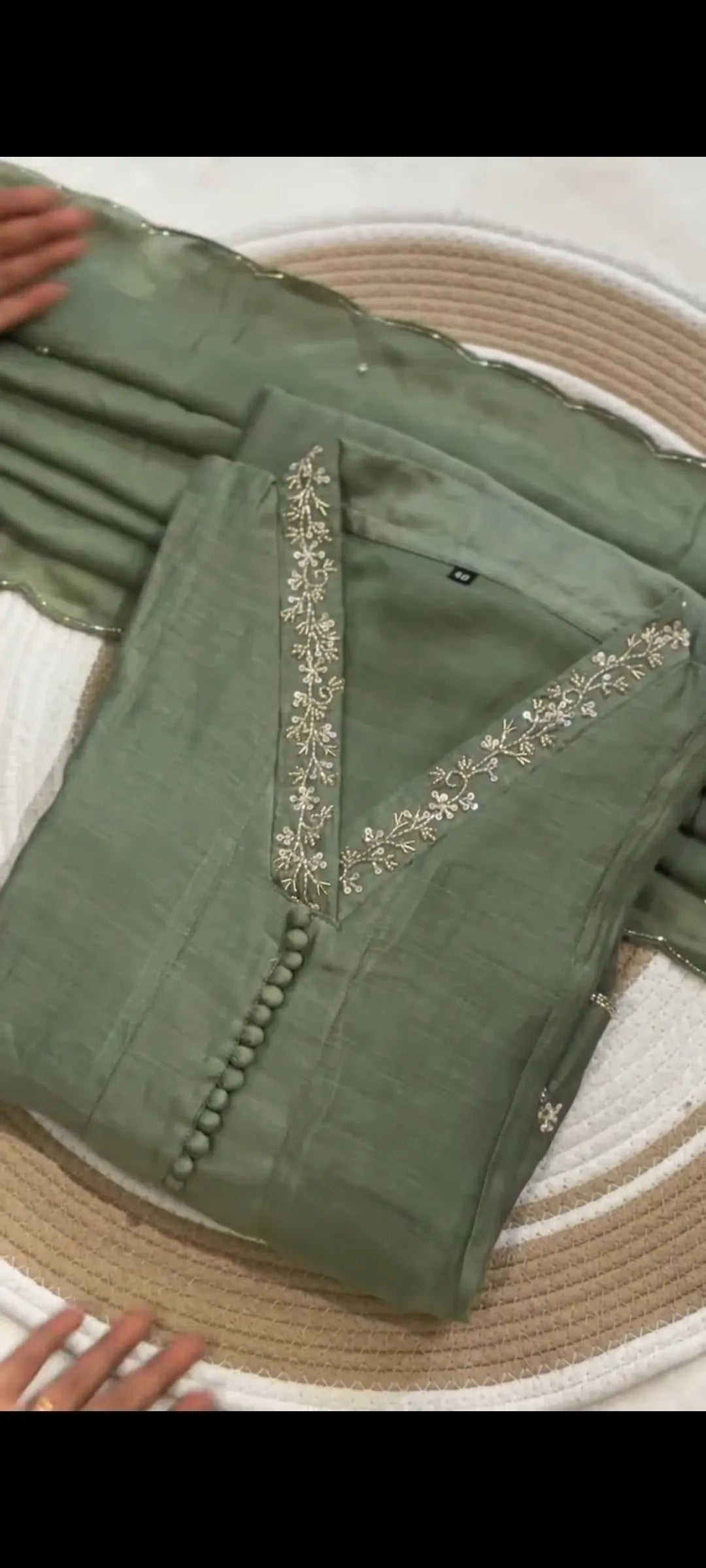 Green saree with intricate patterns on a textured surface