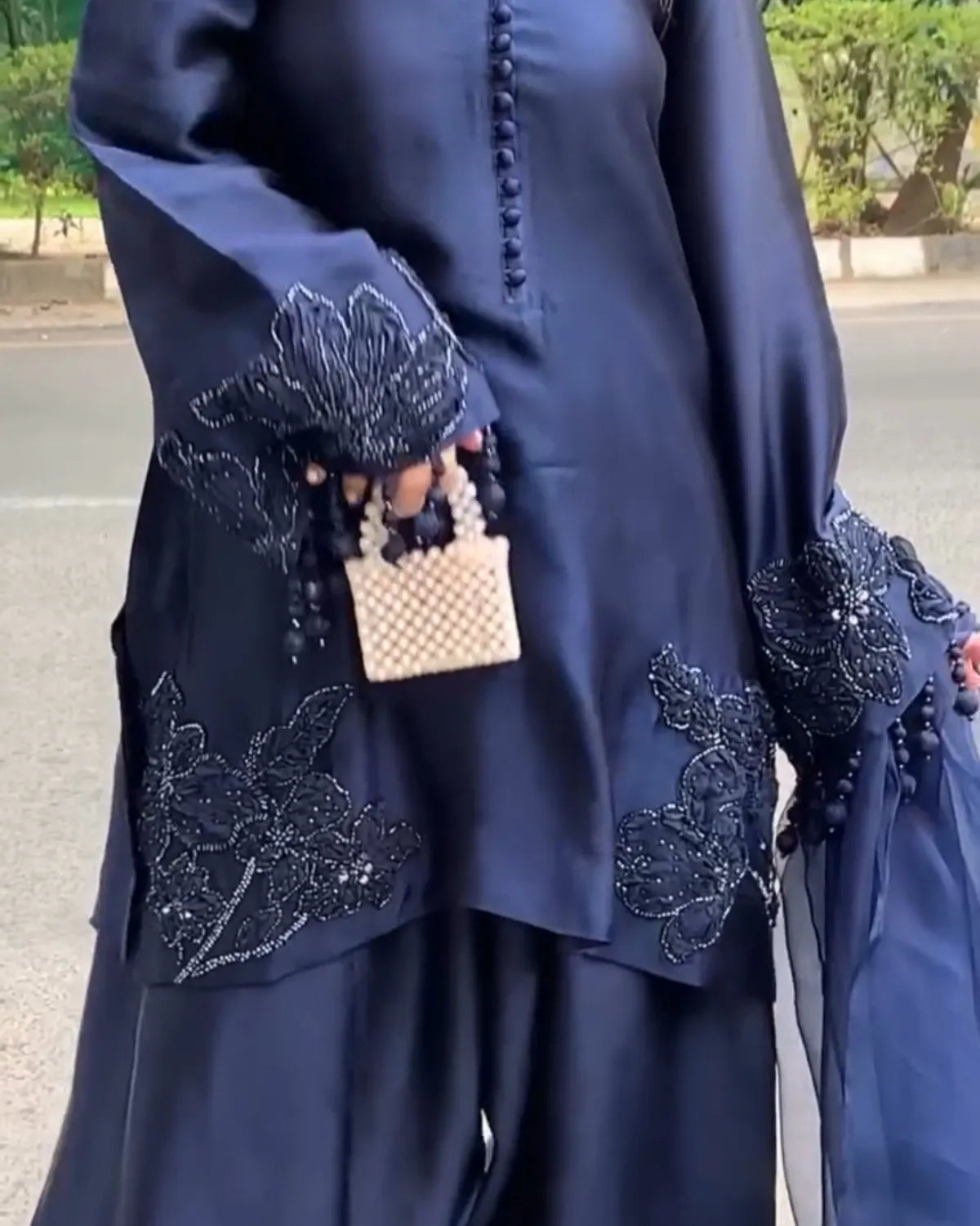 Navy blue outfit with intricate beadwork on a street background