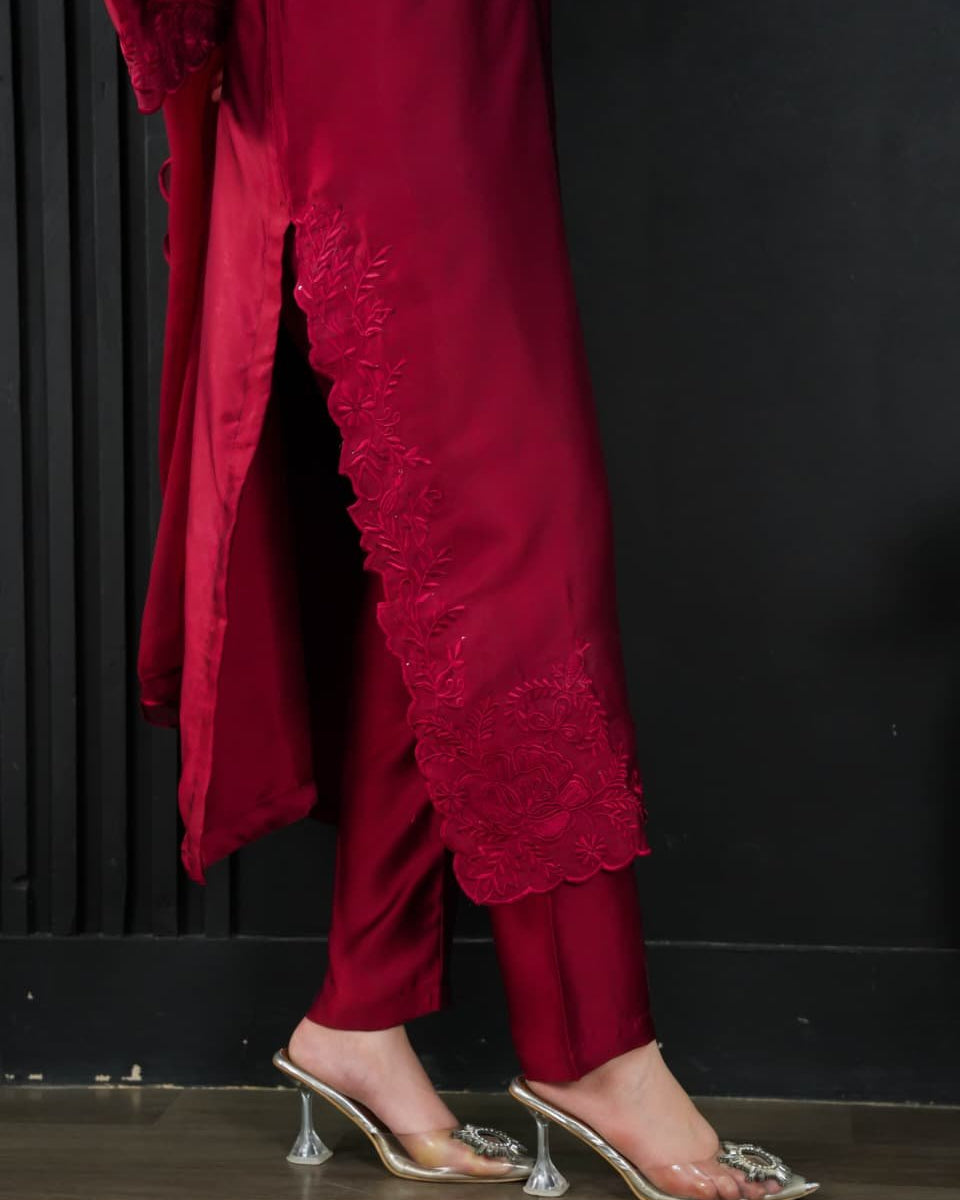 Red outfit with lace details and clear high-heeled shoes on a dark background