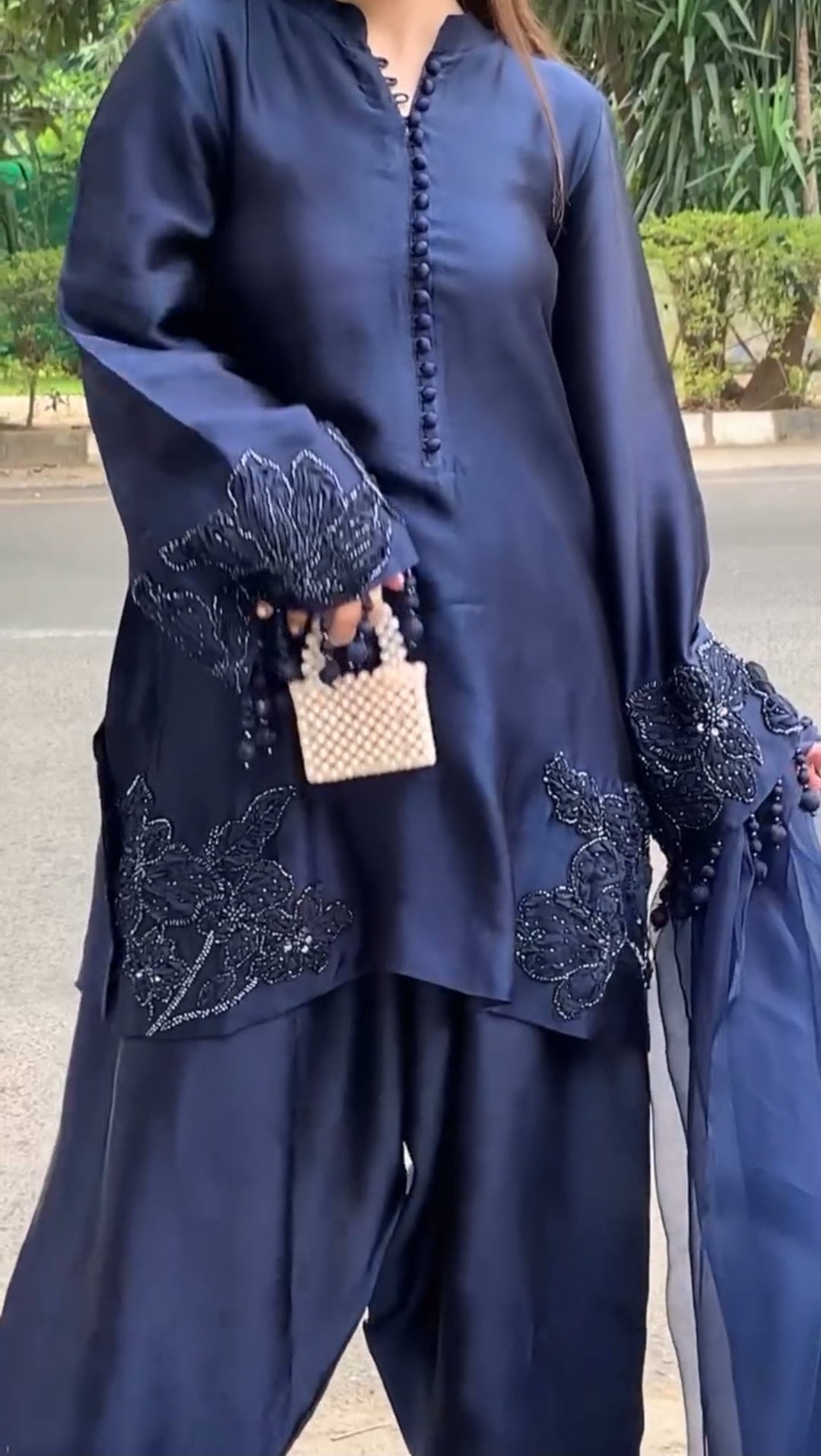 Navy blue traditional outfit with intricate designs on a street background