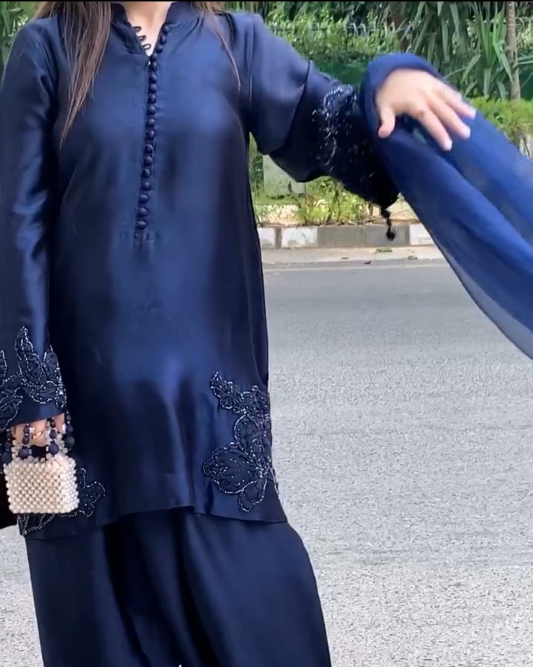Person wearing a navy blue traditional outfit with a matching dupatta on a road background