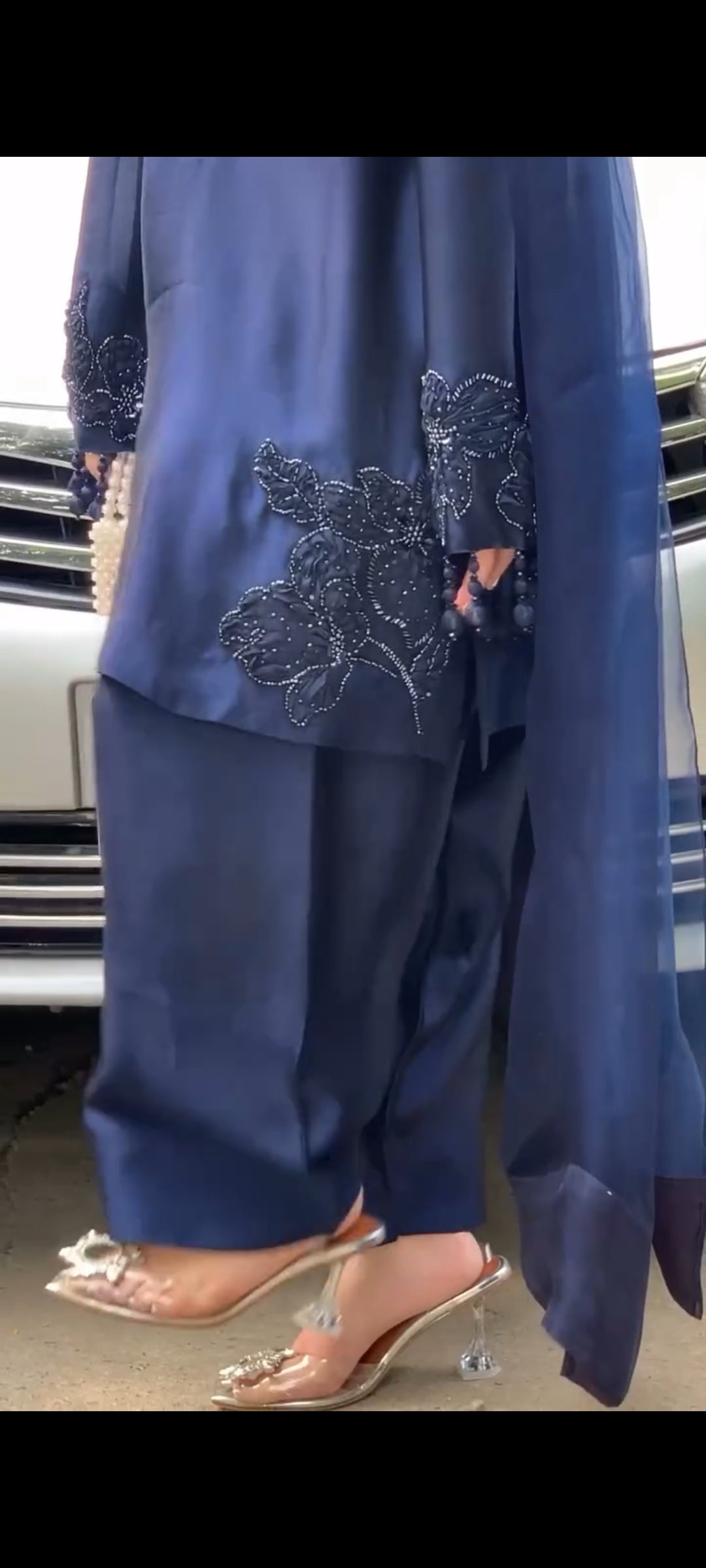 Navy blue outfit with floral embroidery on a vehicle interior background