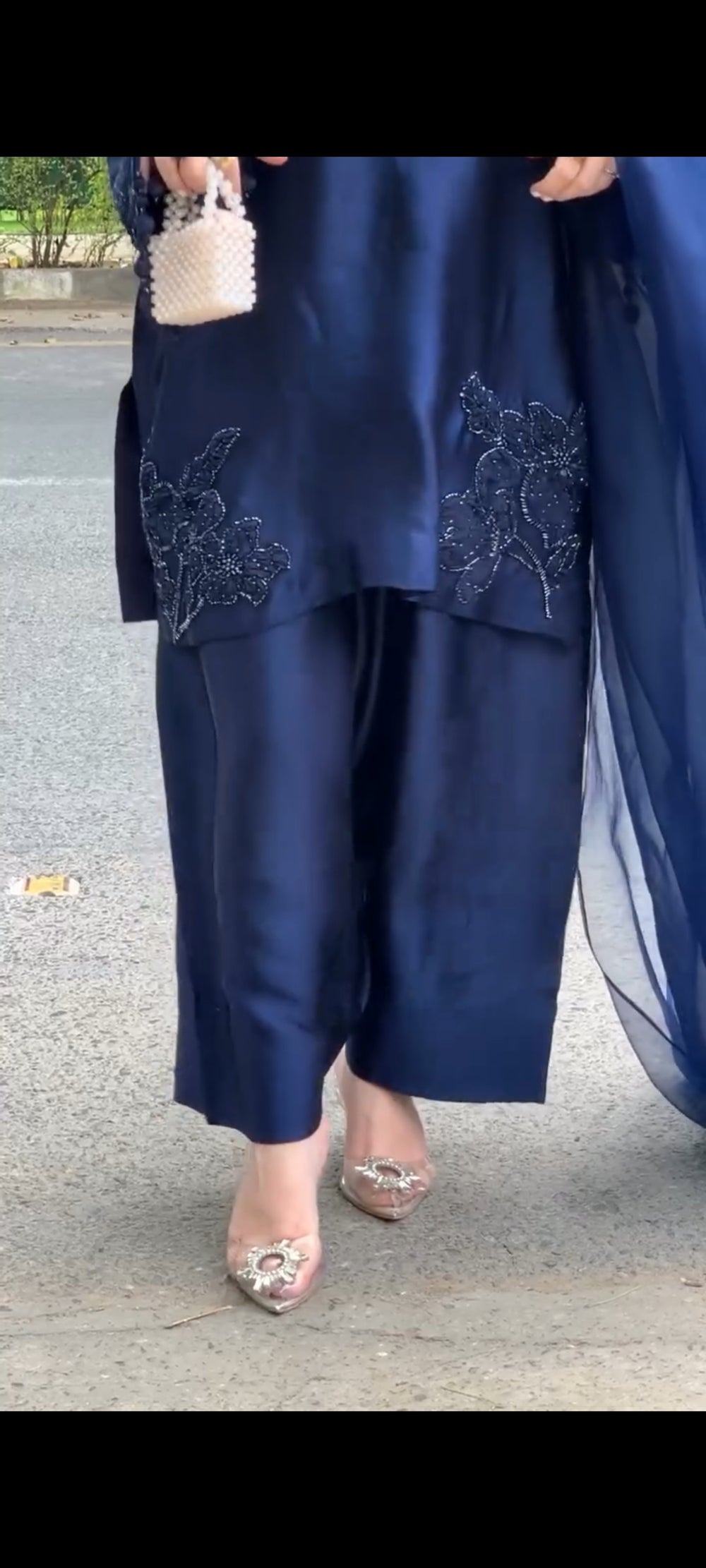 Navy blue outfit with floral embroidery on a street background