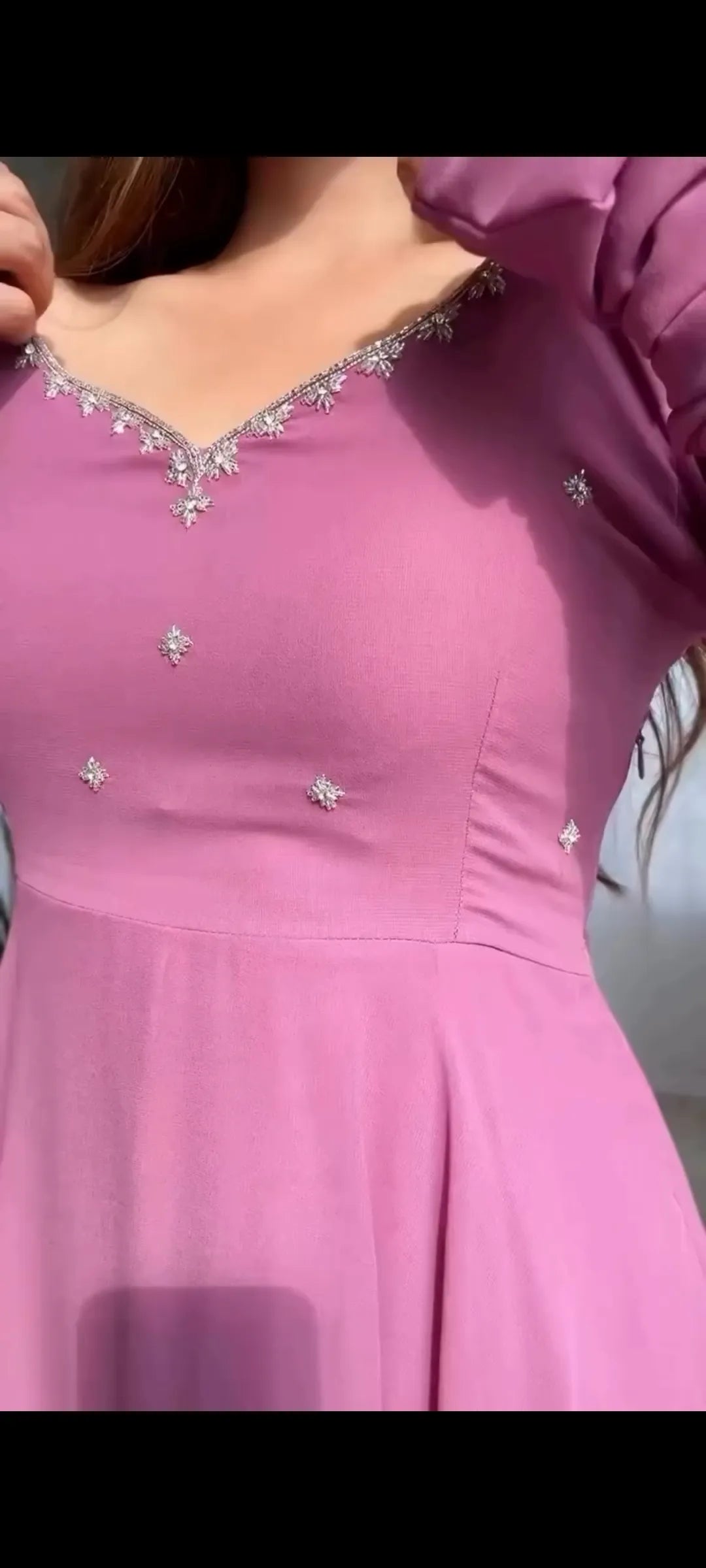 Pink dress with embellishments on a plain background