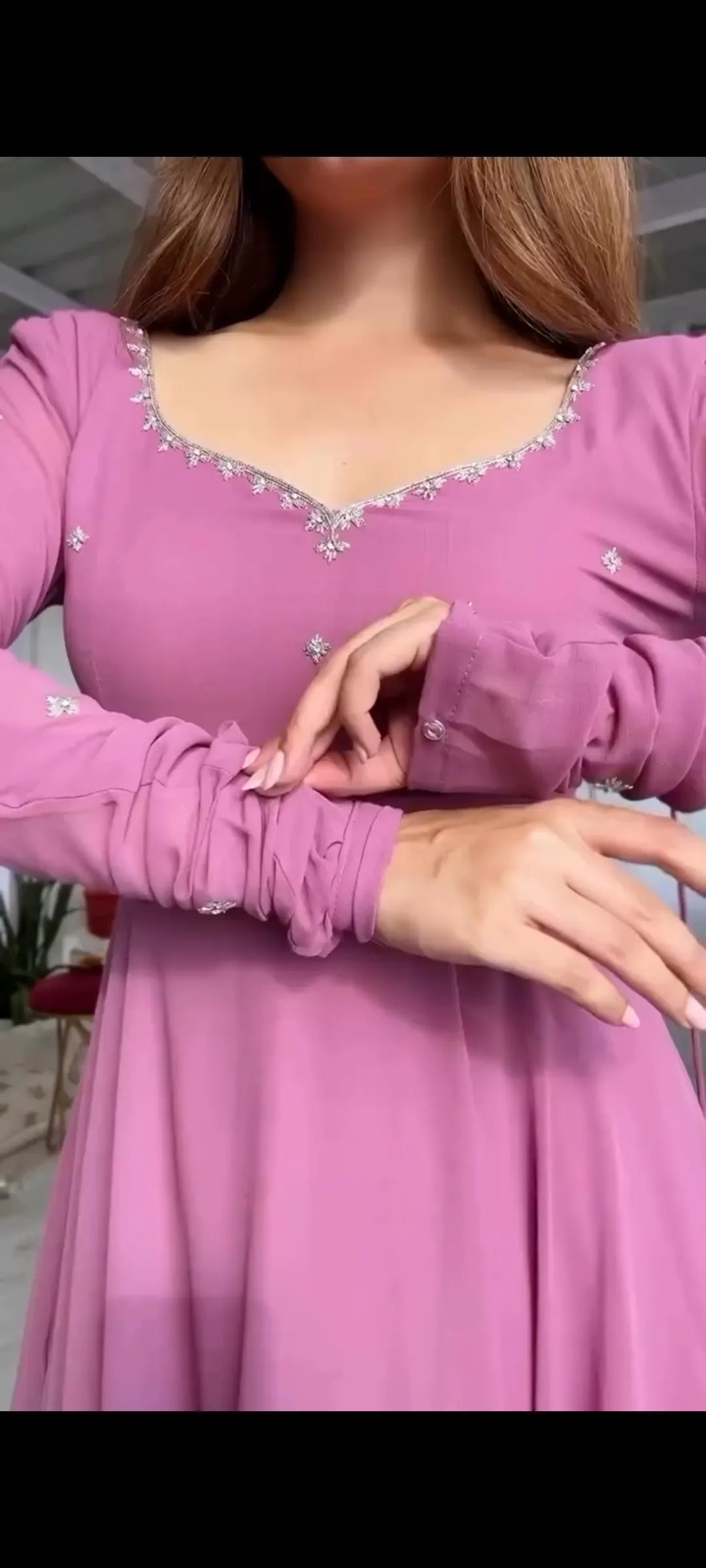 Close-up of a person wearing a pink dress with intricate detailing.