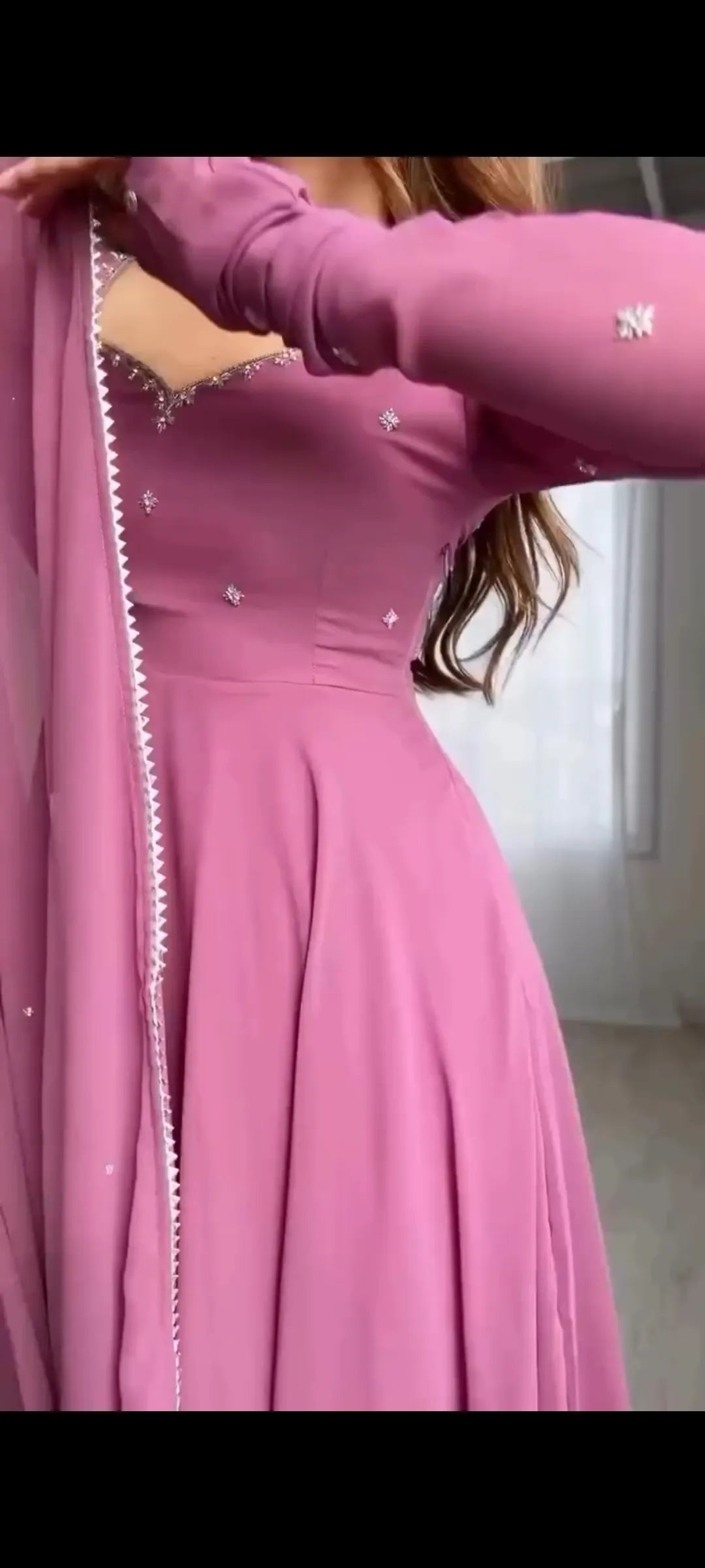 Person wearing a pink dress with a close-up of the fabric and design.