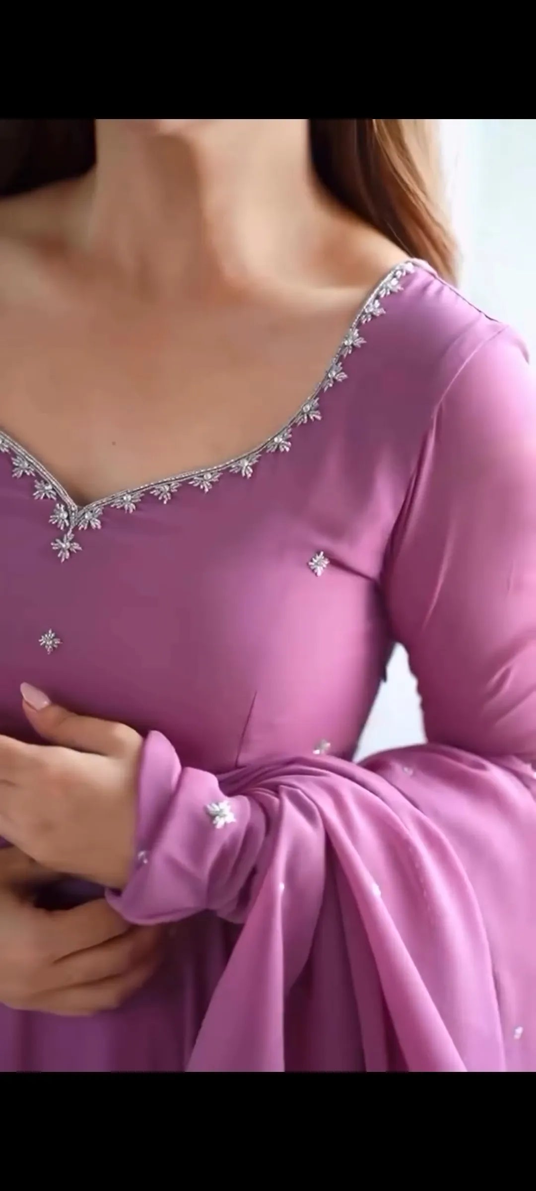 Close-up of a purple dress with intricate detailing on the neckline.