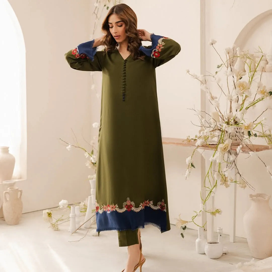 Woman wearing a green dress with floral embroidery in a decorative setting