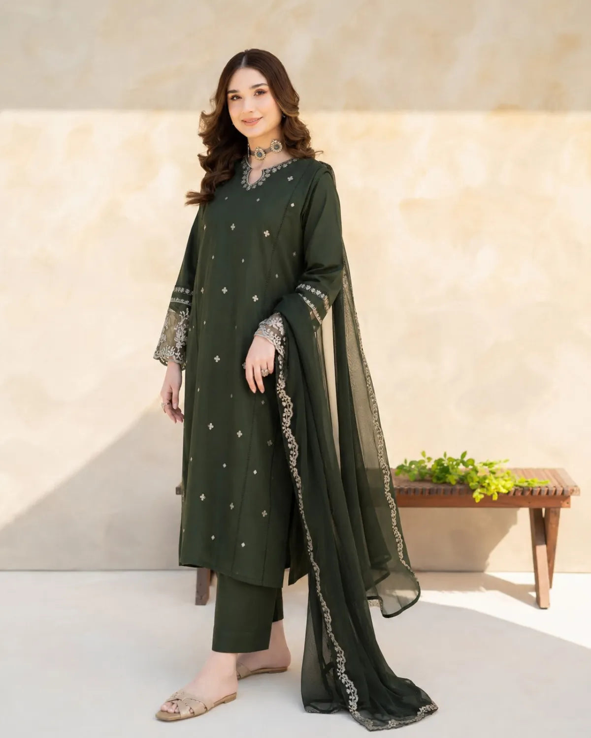 Woman wearing a green traditional outfit with a plain background