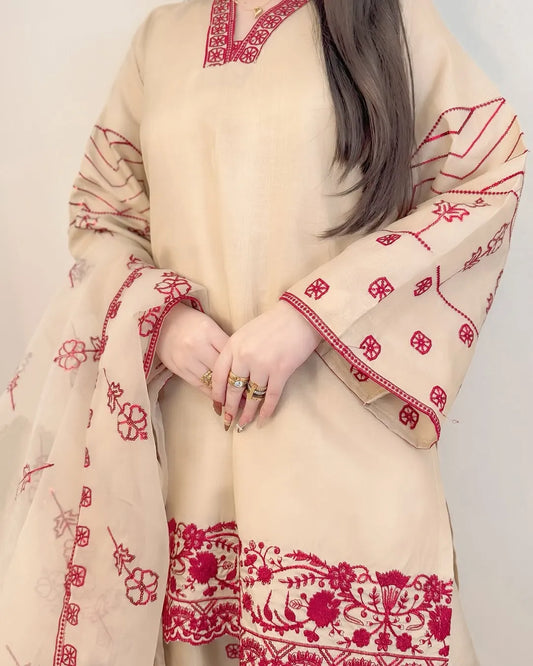 Beige and red embroidered traditional outfit with a plain background