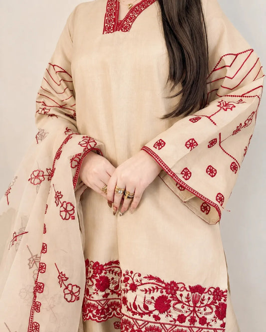 Beige traditional outfit with red embroidery on a plain background