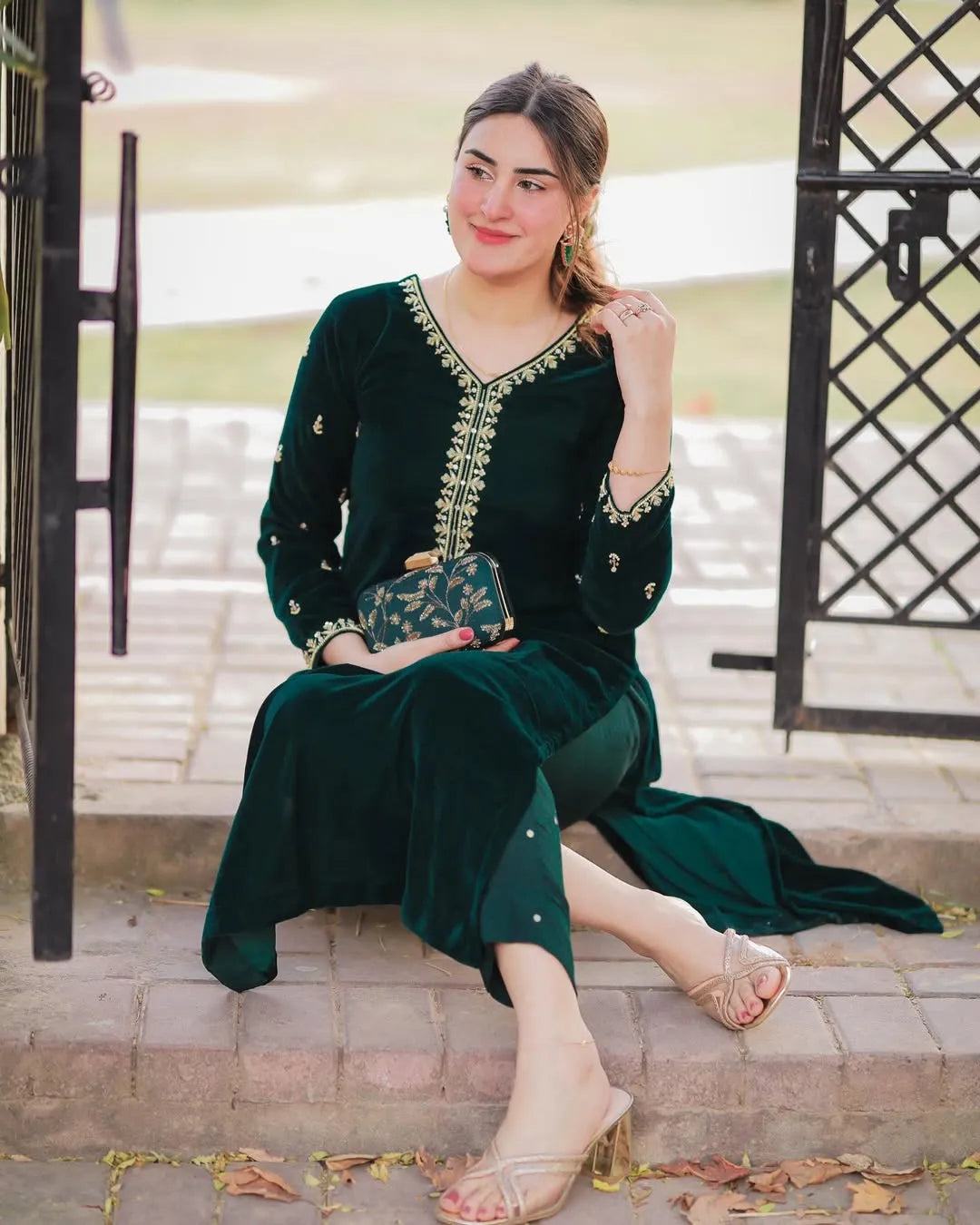 Woman in a green outfit sitting on steps outdoors