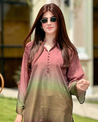 Woman wearing a pink and green outfit with sunglasses outdoors.