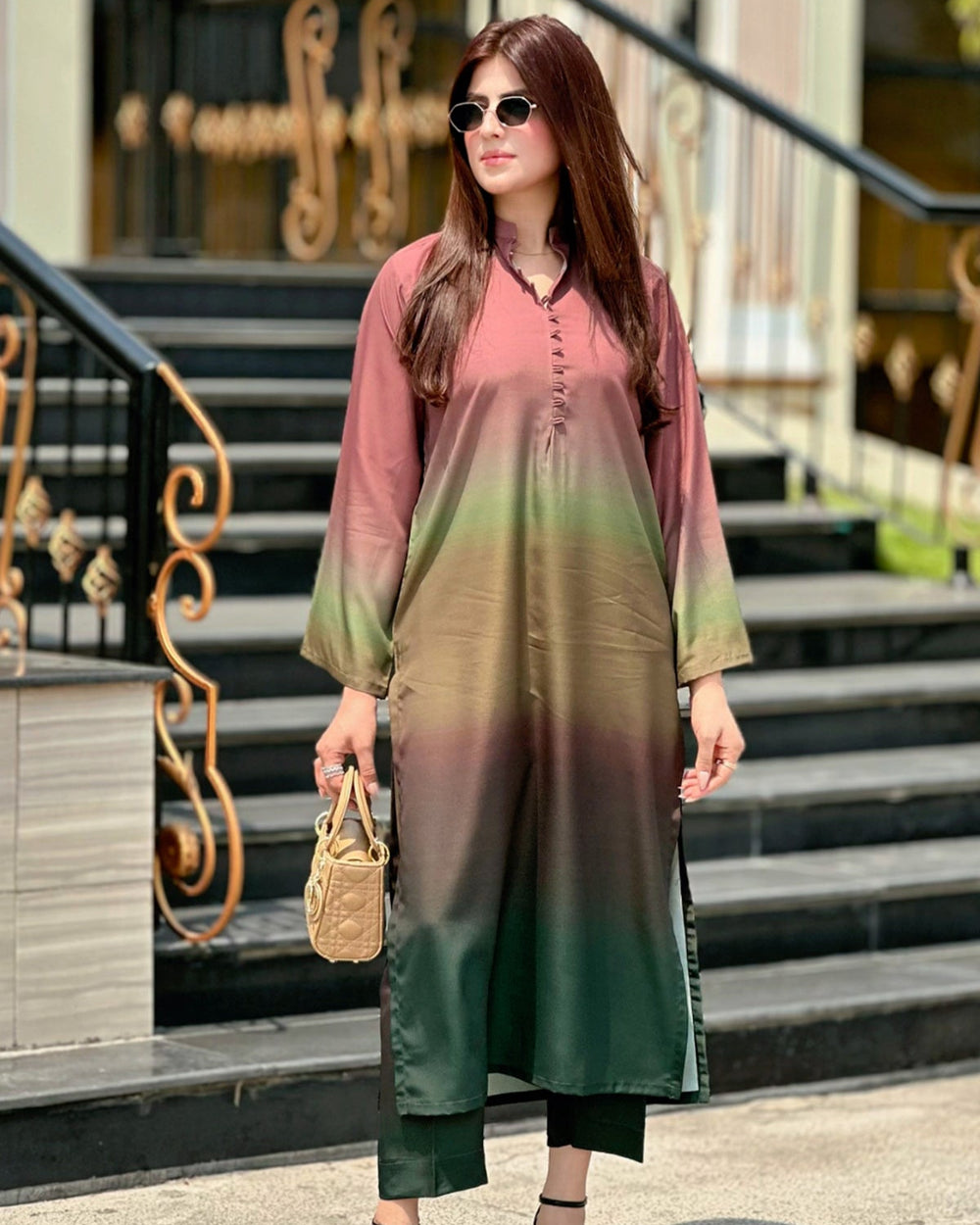 Woman wearing a gradient dress standing on steps outdoors