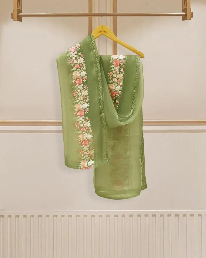 Green embroidered garment on a hanger against a neutral background